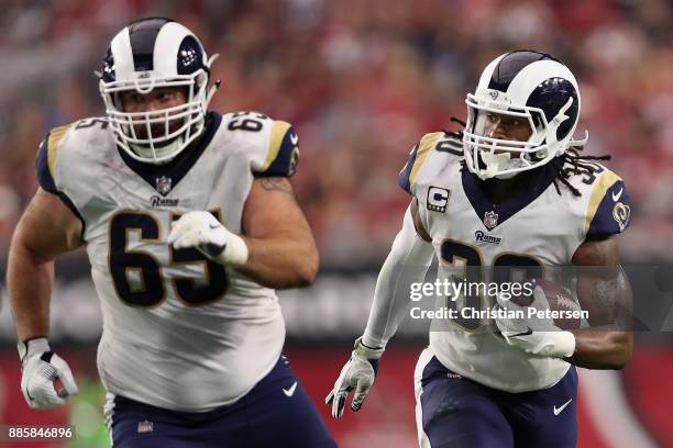 Running back Todd Gurley of the Los Angeles Rams ruhses the football alongside center John Sullivan during the NFL game against the Arizona Cardinals...