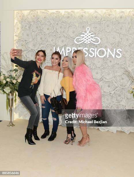 Desi Perkins, Isabel Bedoya, and Melly Sanchez pose with fan at Impressions Vanity Melrose Grand Opening Gala on December 4, 2017 in Los Angeles,...