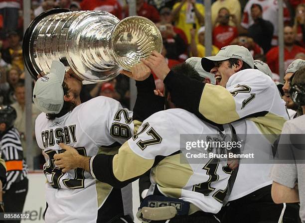 Sidney Crosby, Petr Sykora and Evgeni Malkin of the Pittsburgh Penguins celebrate with the Stanley Cup following the Penguins victory over the...