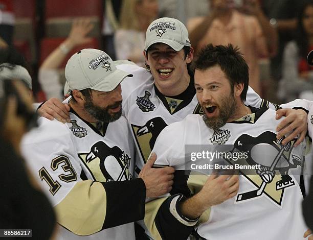 Bill Guerin, Evgeni Malkin and Petr Sykora of the Pittsburgh Penguins celebrate following the Penguins victory over the Detroit Red Wings in Game...