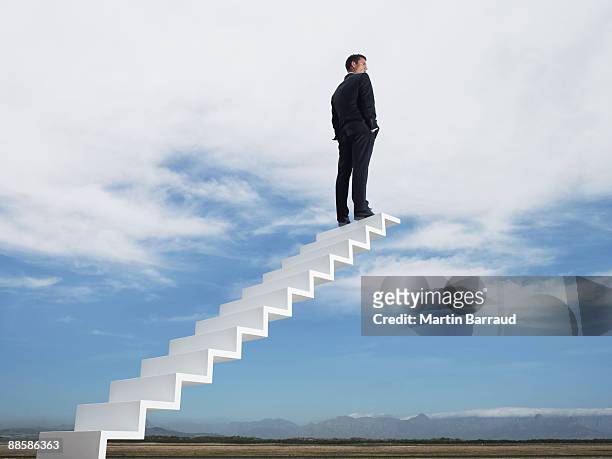 businessman at end of stairway leading to the sky - 階段　のぼる ストックフォトと画像