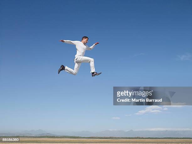 man jumping in desert - human limb stock pictures, royalty-free photos & images