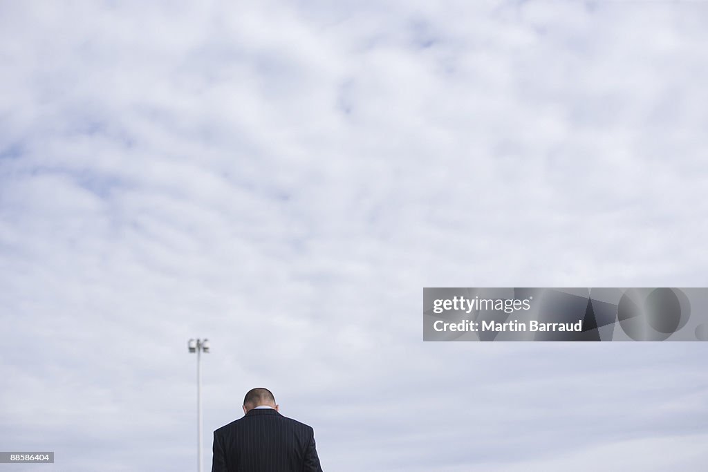 Rear view of businessman and cloudy sky