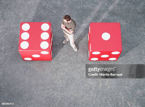 man looking at pair of giant dice - dice pair stock-fotos und bilder