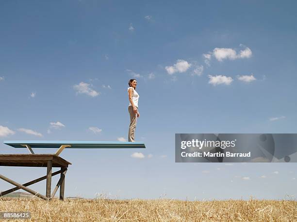 woman standing on diving board in field - diving platform stock pictures, royalty-free photos & images