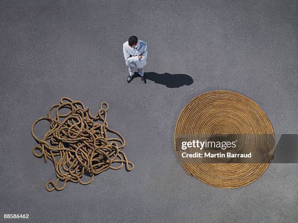 businessman looking at coiled and tangled rope - kings of chaos in south africa stockfoto's en -beelden