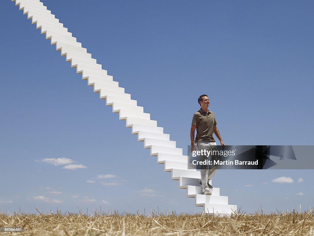 Man descending stairway in field