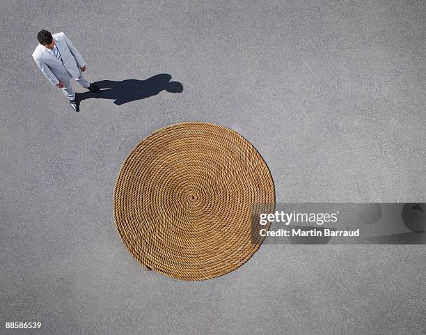 businessman looking at coiled rope - rug stock pictures, royalty-free photos & images