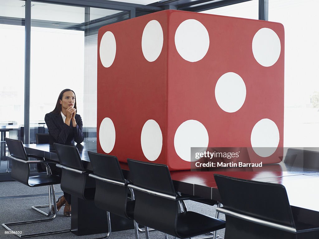 Businesswoman in conference room looking at giant dice
