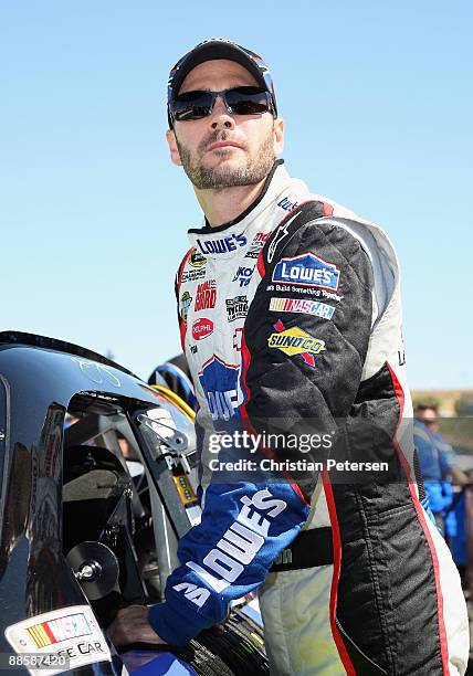 Jimmie Johnson, driver of the Lowe's Chevrolet, climbs out of his car during qualifying for the NASCAR Sprint Cup Series Toyota/Save Mart 350 at the...