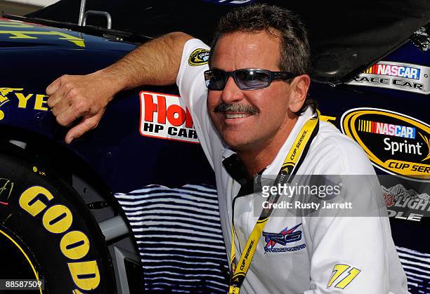 Kevin Buckler, owner of the Adobe Road Winery Chevrolet poses for photographers by his car during qualifying for the NASCAR Sprint Cup Series...