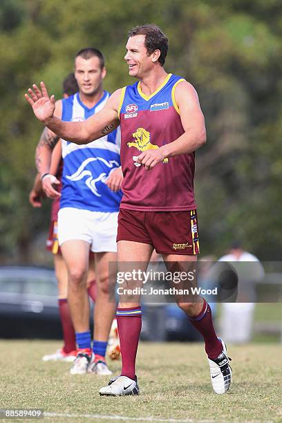 Wayne Carey of the Lions leaves the field of play injured during the QAFL Pineapple Hotel Cup Division Two match between the Palm Beach-Currumbin...