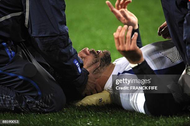 France's winger Vincent Clerc lies on the field and receives attention from the physio during their rugby union Test match against the New Zealand...