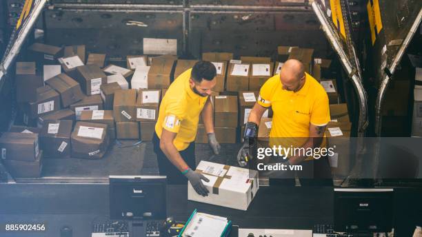 två post-lagerarbetare scanning ett paket - sortering bildbanksfoton och bilder