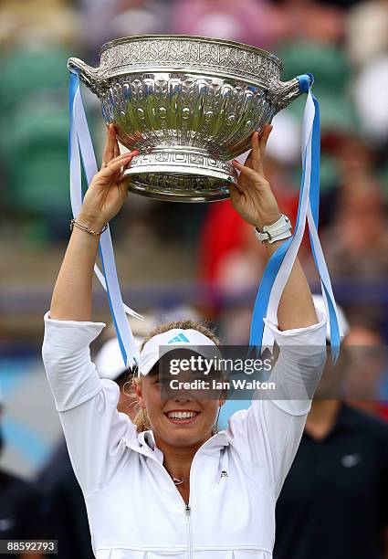 Caroline Wozniacki of Denmark celebrates with the trophy after winning the final match against Virginie Razzano of France on day six of the AEGON...