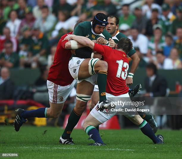 Pierre Spies of South Africa is tackled by Brian O'Driscoll during the First Test match between the South African Springboks and the British and...