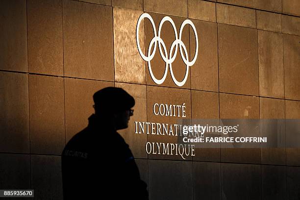 Private security personnel guards the entrance of the International Olympic Committee headquarters in Pully, near Lausanne, prior to an executive...