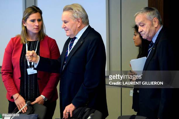 International Olympic Committee members Denis Oswald of Switzerland speaks with Angela Ruggiero from the United States, next to Gian-Franco Kasper...