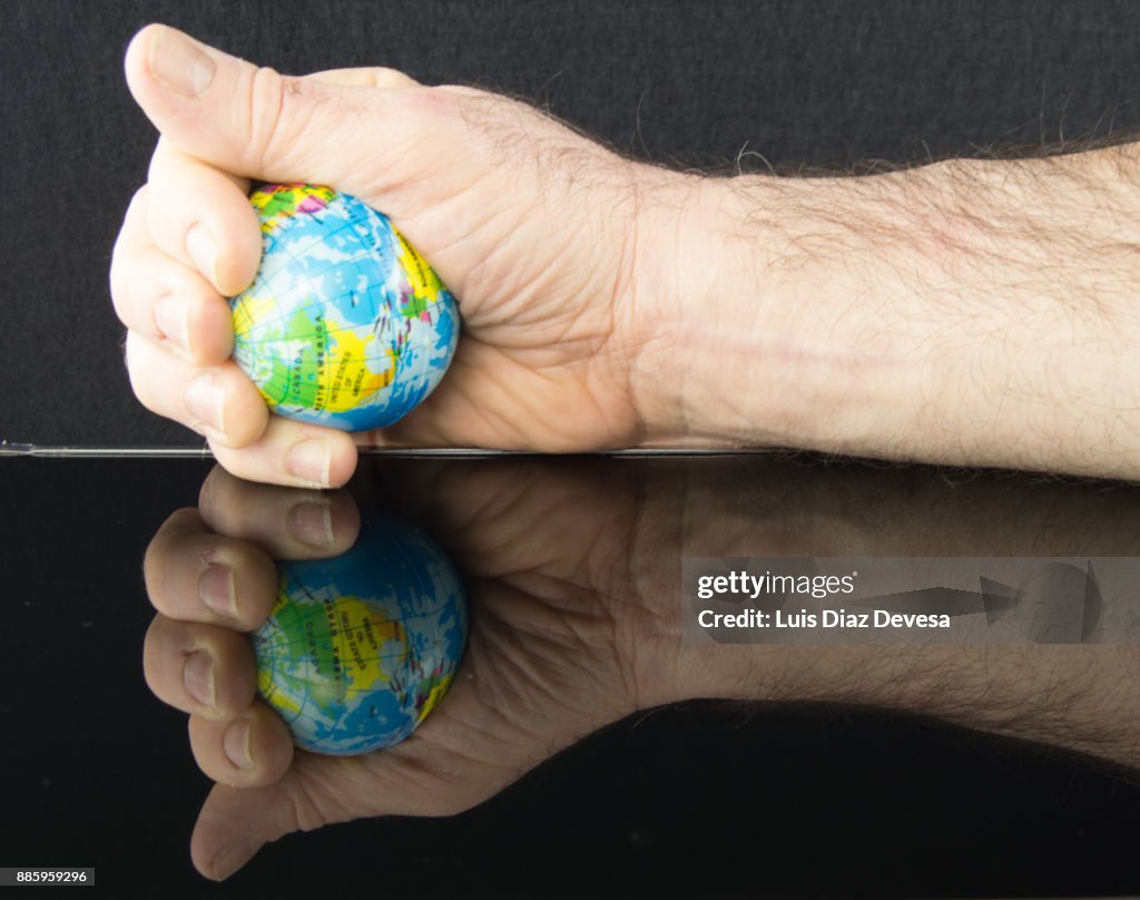 Man squeezing therapy ball shaped like planet earth