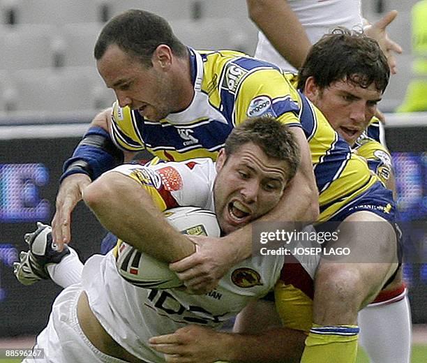 Warrington Wolves' Louis Andreson tackles Catalans Dragons' Casey McGuire during their Superleague rugby XIII match at the Olympic Stadium in...