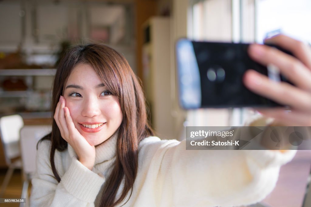 Young woman taking selfie picture in cafe