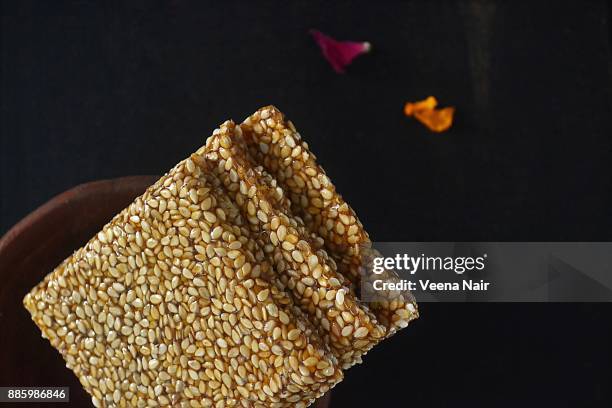 close-up of sesame brittle/chikki in a clay bowl-indian snack - pongal stock pictures, royalty-free photos & images