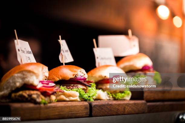 fresh flame grilled burgers displayed in a row at food market - pattie sellers stock pictures, royalty-free photos & images