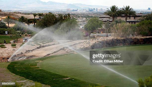 Hotel-casinos on the Las Vegas Strip are seen behind sprinklers watering the golf course at DragonRidge Country Club June 19, 2009 in Henderson,...