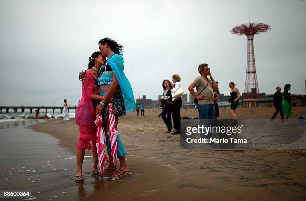 Hamilton and Emiko Harama hug by the ocean after marching in the 2009 Mermaid Parade at Coney Island June 20, 2009 in the Brooklyn borough of New...