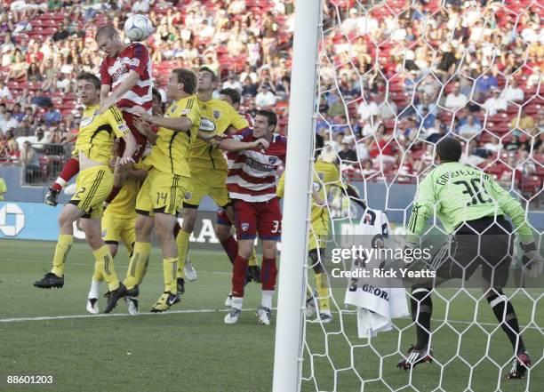 Kyle Davies of the FC Dallas heads the ball surrounded by Eddie Gaven and Chad Marshall of the Columbus Crew at Pizza Hut Park on June 20, 2009 in...