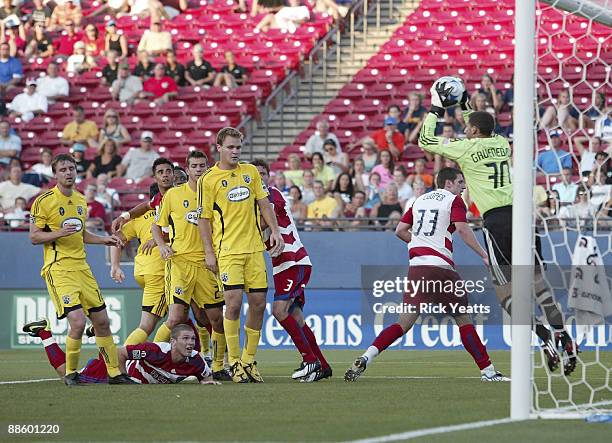 Andy Gruenebaum of the Columbus Crew makes a save off a header by Kyle Davies of the FC Dallas surrounded by Eddie Gaven and Chad Marshall of the...