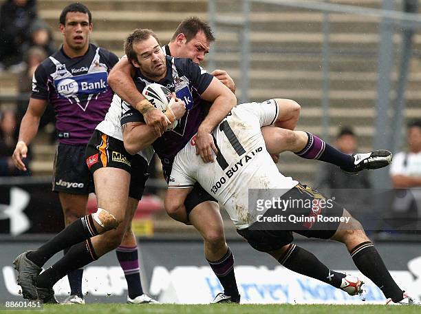 Scott Anderson of the Storm is tackled by Todd Payten of the Tigers during the round 15 NRL match between the Melbourne Storm and the Wests Tigers at...