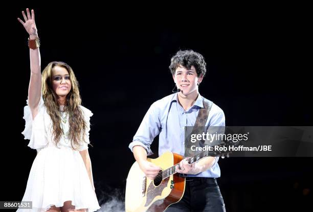 Musicians Miley Cyrus and Nick Jonas of Jonas Brothers perform at New Cowboys Stadium on June 20, 2009 in Dallas, Texas.