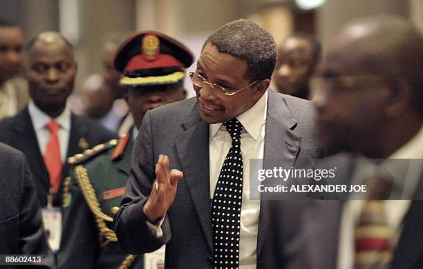 Tanzania's President Jakaya Kikwete talks to unidentified officials at the Southern African Development Community special summit on Madagascar in...