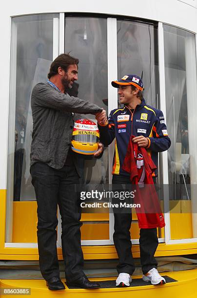Former Manchester United and French international footballer Eric Cantona and Fernando Alonso of Spain and Renault are seen in the paddock before the...