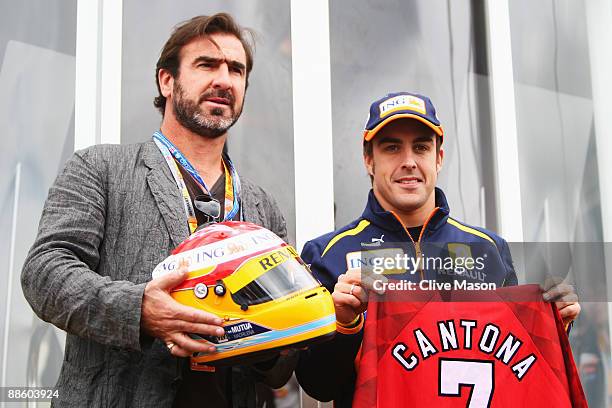 Former Manchester United and French international footballer Eric Cantona and Fernando Alonso of Spain and Renault are seen in the paddock before the...