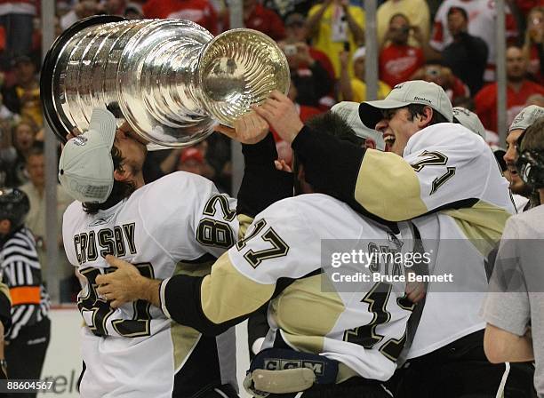 Sidney Crosby, Petr Sykora and Evgeni Malkin of the Pittsburgh Penguins celebrate with the Stanley Cup following the Penguins victory over the...