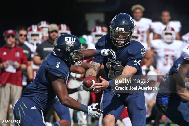 Alex McGough hands the ball off to Alex Gardner of the Florida International Golden Panthers xx of the Massachusetts Minutemen on December 2, 2017 at...