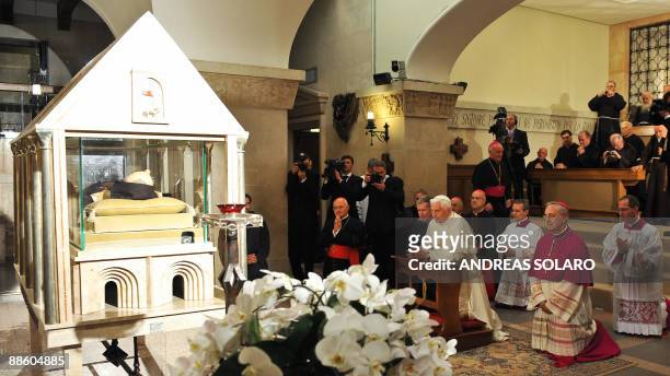Pope Benedict XVI prays at the crypt of St. Mary of Grace dedicated to Padre Pio's body as the corpse of the friar lies in a coffin glass in San...