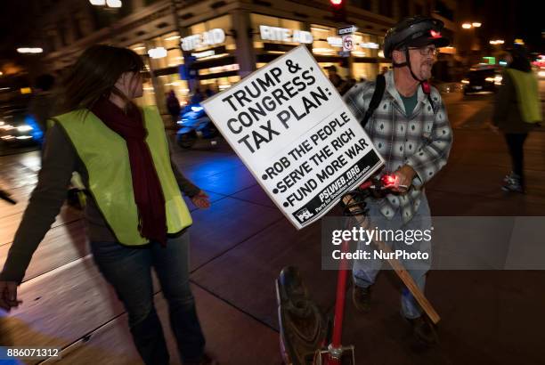 People take part in a protest against the Republican tax bill in Los Angeles, California on December 4, 2017. Democrats and many economists warn that...