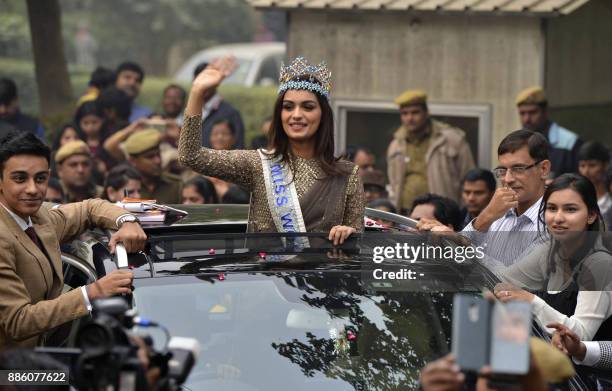 Miss World 2017 Manushi Chhillar waves as she stands out of the sunroof of a car during a parade in New Delhi on December 3, 2017. Indian model...