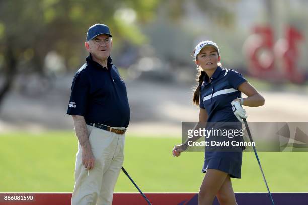 Sophie Lamb of England the young amateur follows her tee shot watched by Peter Dawson the Chairman of the Omega Dubai Ladies Classic during the...