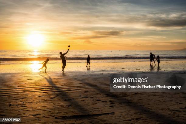 beach football during sunset in los angeles - children playing silhouette stock pictures, royalty-free photos & images
