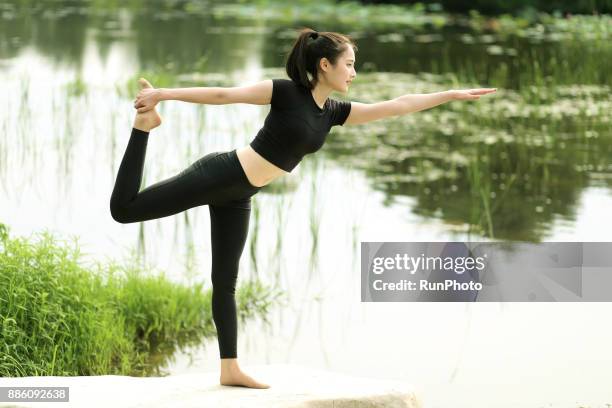 woman doing yoga in the park - lord of the dance pose stock pictures, royalty-free photos & images