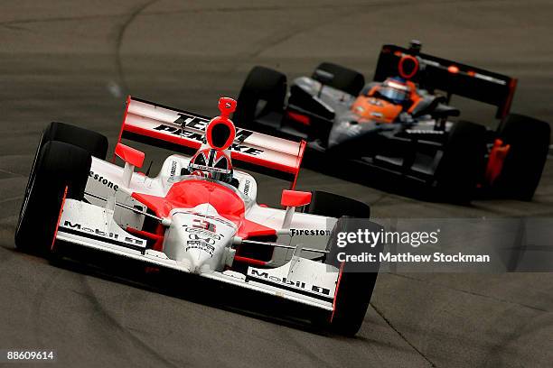 Helio Castroneves, driver of the Team Penske Dallara Honda, leads Danica Patrick, driver of the Boost Mobile Motorola Andretti Green Racing Dallara...