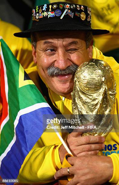 Clovis Acosta Fernandes holds up a replica of the World Cup trophy during the FIFA Confederations Cup match between Italy and Brazil at the Loftus...