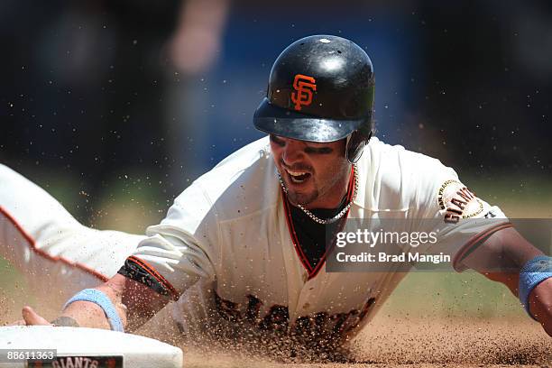 Aaron Rowand of the San Francisco Giants slides safely into third base after going first to third on a single in the seventh inning against the Texas...