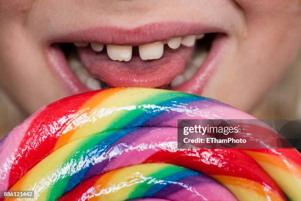 10 year-old blond boy eating large colorful lollipop - androgynous boys stock pictures, royalty-free photos & images