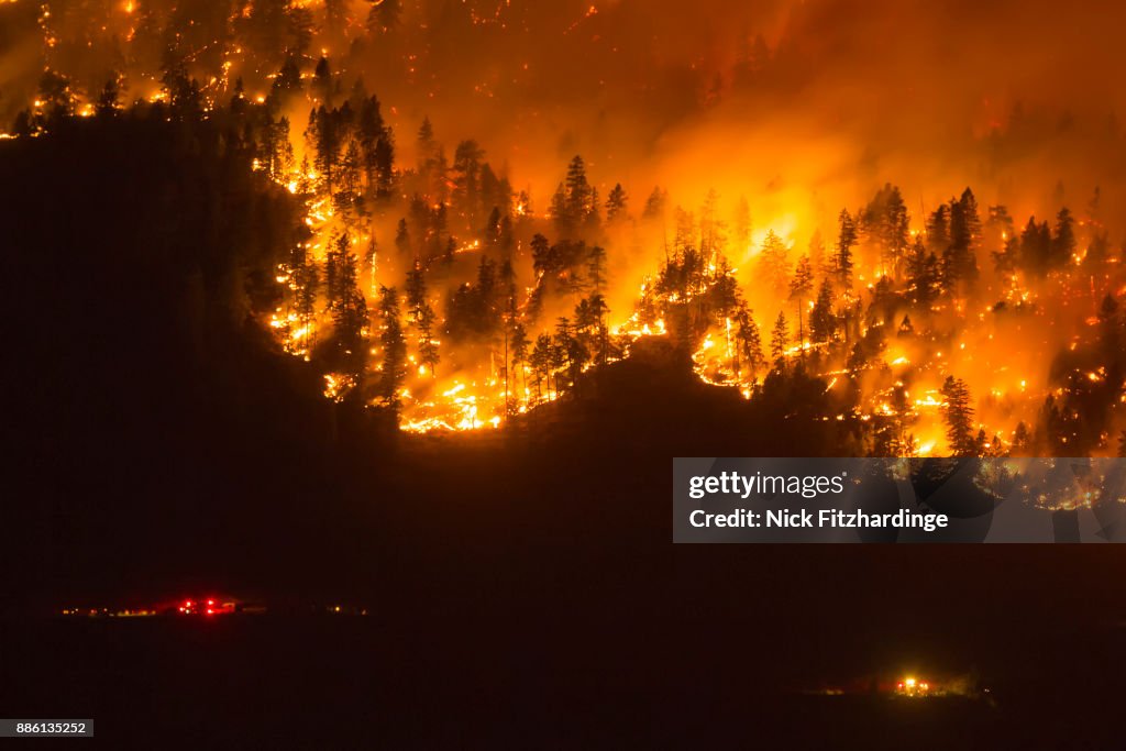 A wildfire frontline with emergency services nearby, Okanagan Valley, British Columbia, Canada