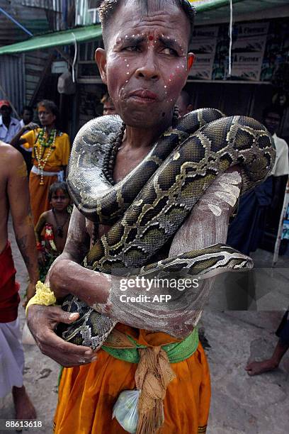 Photo taken May 8, 2009 shows a Hindu man holding a snake during a fire festival in the Yankin township of Kanbet in Yangon, Myanmar. Despite there...